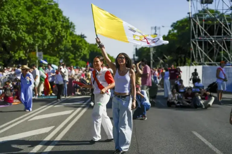 A young woman carries a Vatican flag near Plaza de Lima.