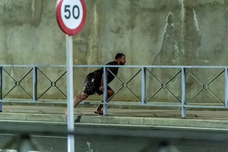 Migrant running through the streets of Ceuta after accessing the city by swimming