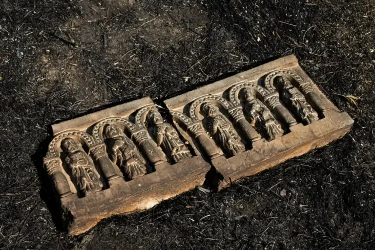 A stone frieze lying among the grass was burning.