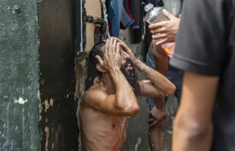 A Moroccan man washes himself, yesterday, thanks to a faucet with running water set up next to the Temporary Stay Center for Immigrants in Ceuta.