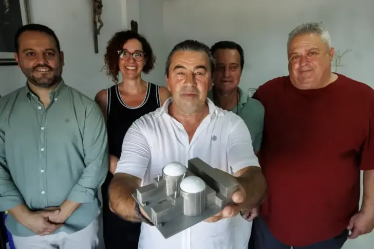 The mayor of Almaraz holds a model of the nuclear power plant alongside other local councilors from the area.