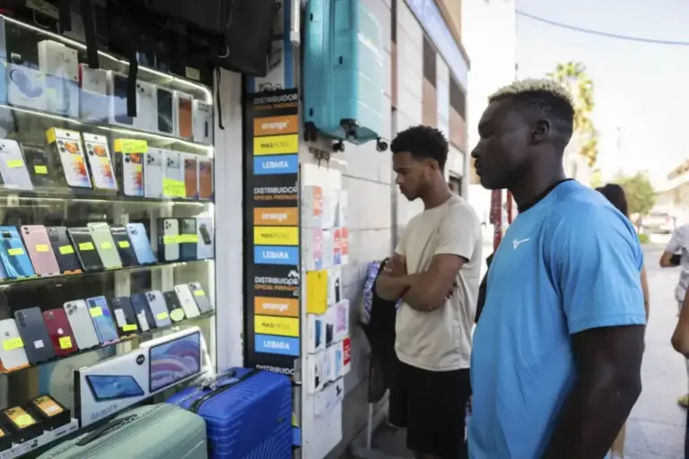 Migrants looking at a phone store in the city of Ceuta