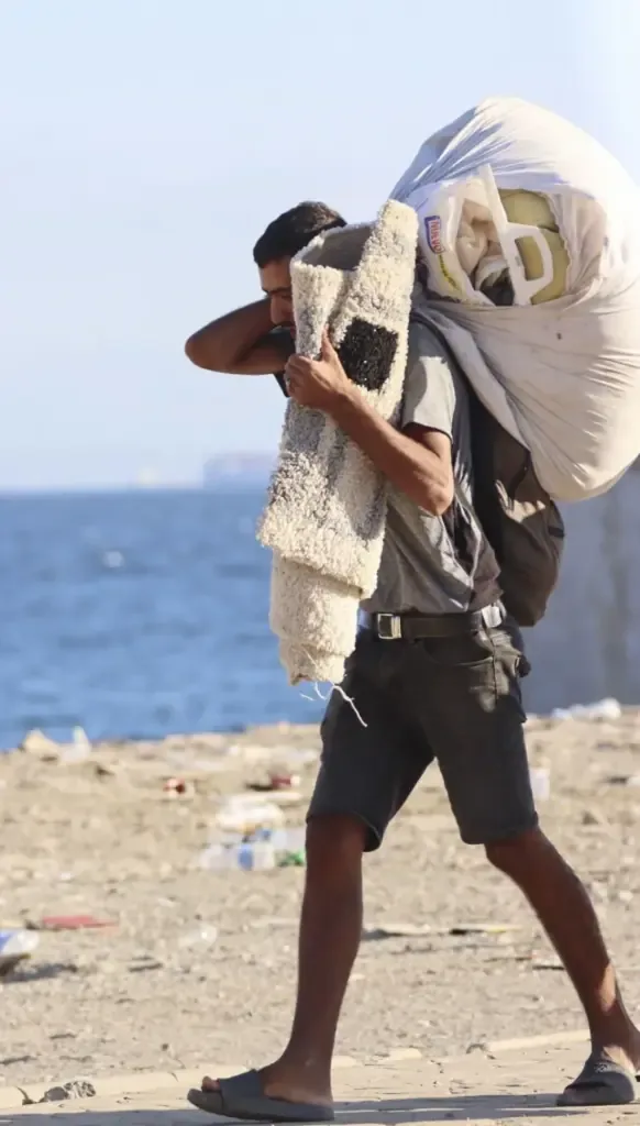 A migrant leaves Trampolín, with his belongings.