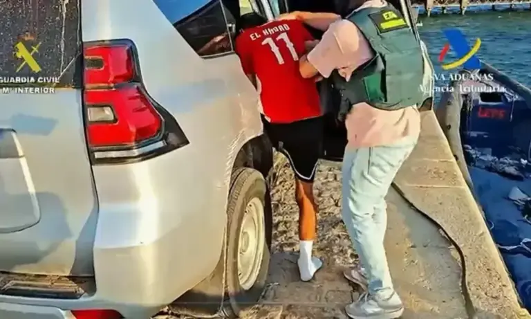 An officer, with one of the detainees.