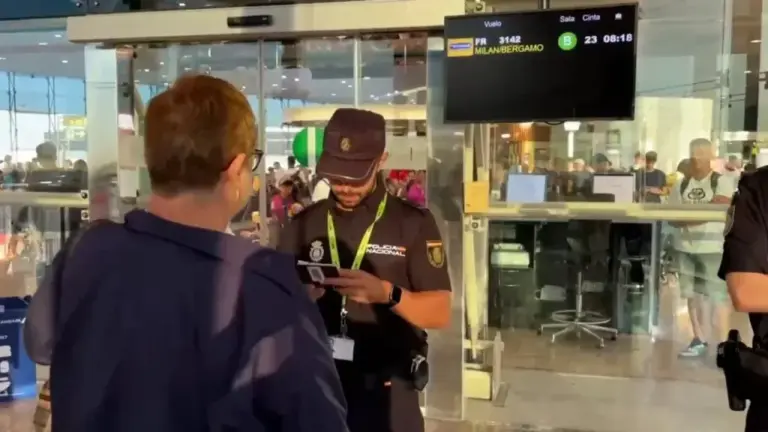 A police officer checks the documentation of a passenger coming from Milan.