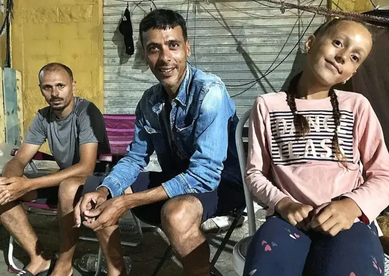 Mustafa, con su sobrina Ritaj a la derecha y su amigo Jouchal a la izquierda, en el polígono de El Tarajal el miércoles por la noche.