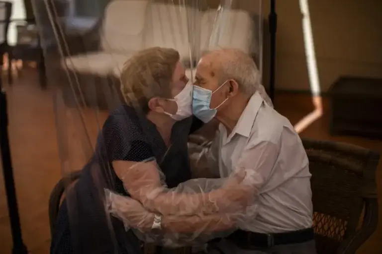 A couple kisses through plastic in a residence in Barcelona in June 2020
