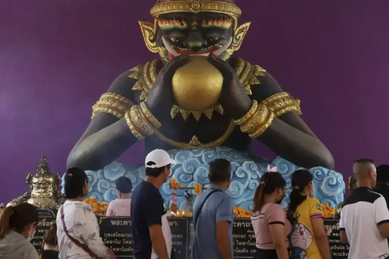Devotees in front of the figure of Rahu at the Wat Bang Chak temple (Thailand).