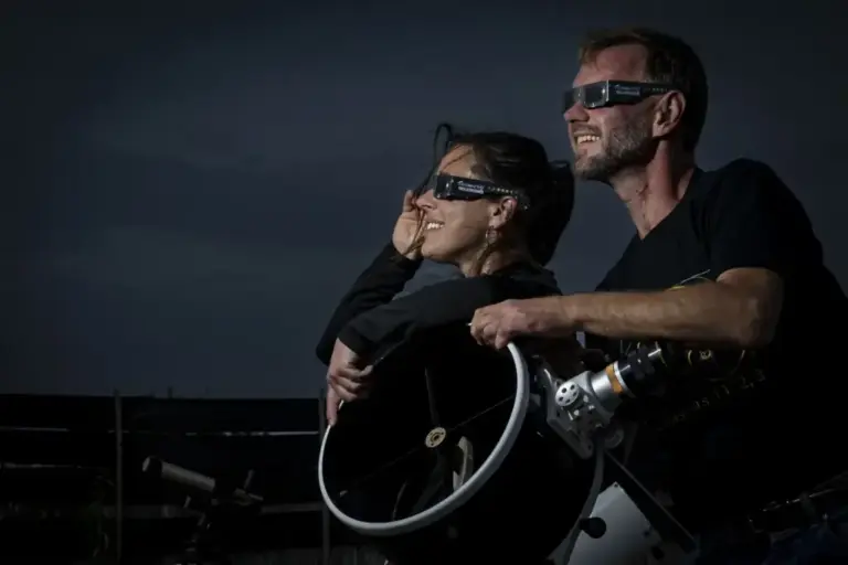 Two people watching the eclipse with special protective glasses
