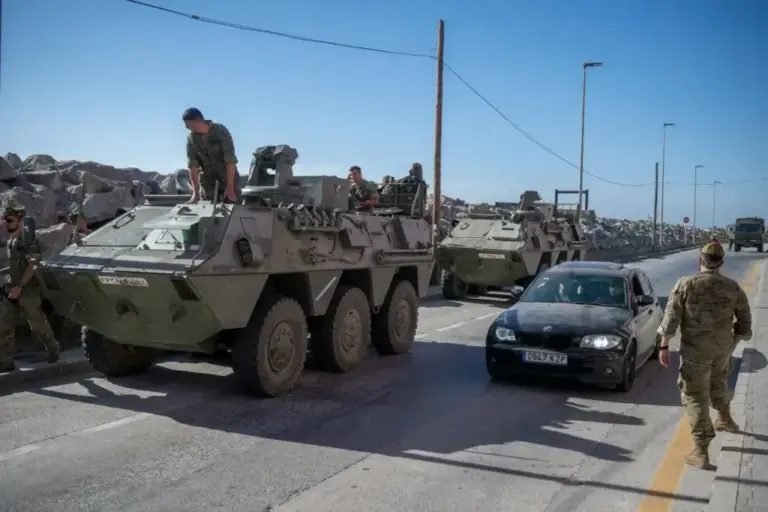 A military convoy with two armored vehicles patrols a road in Ceuta.