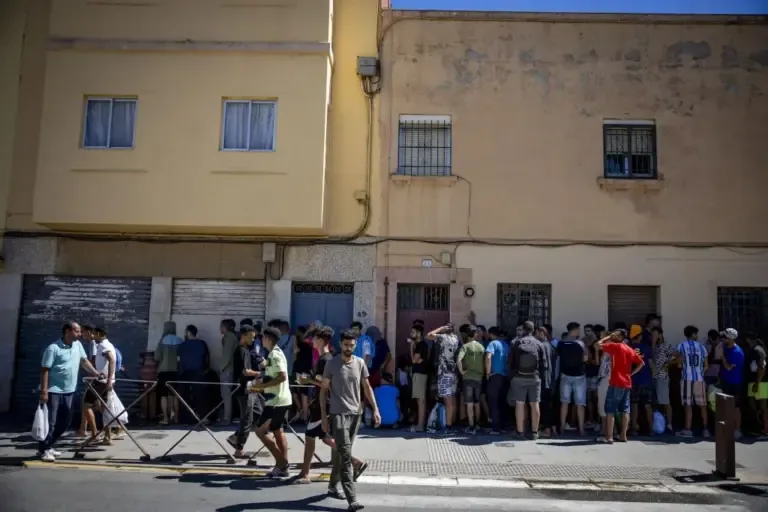 Line of immigrants waiting to eat or shower at Sabah’s house.