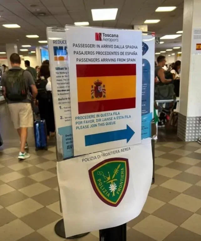 A sign at an Italian airport points to the line passengers coming from Spain must go to.