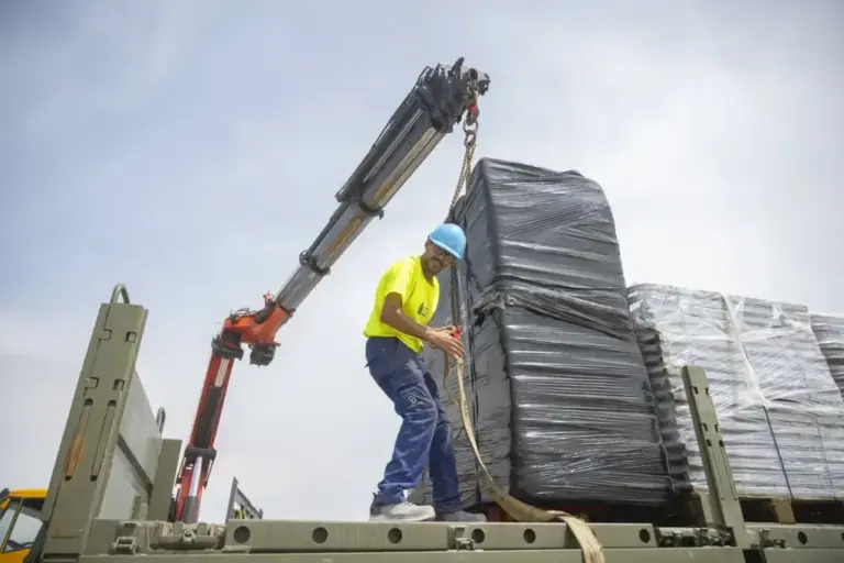 A worker unloads material from the military truck in front of the Los Rosales daycare center.