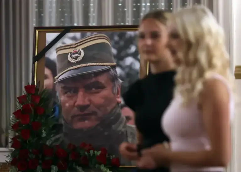 Two women pass by a portrait of Ratko Mladic at the military farewell this Saturday in Belgrade.
