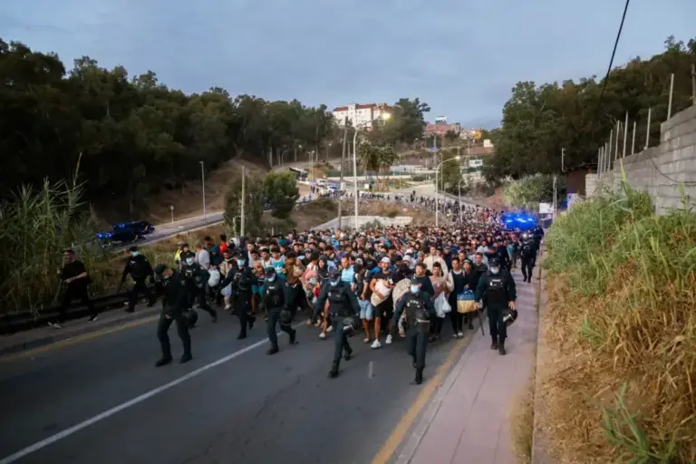 The Police transfer migrants through the streets of Ceuta.